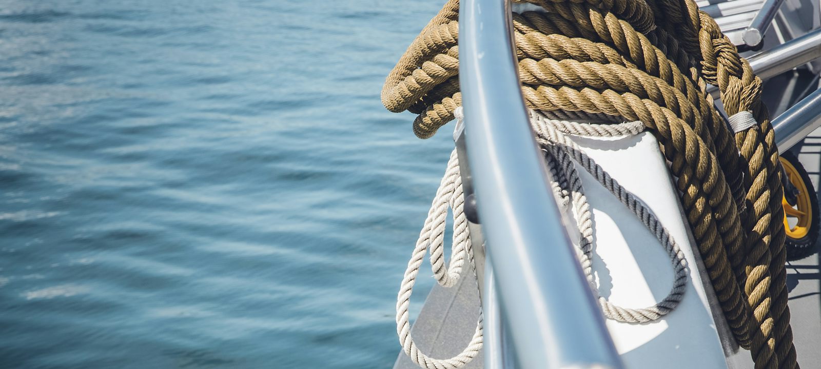 Cabo enrollado en la cubierta de un barco sobre el agua