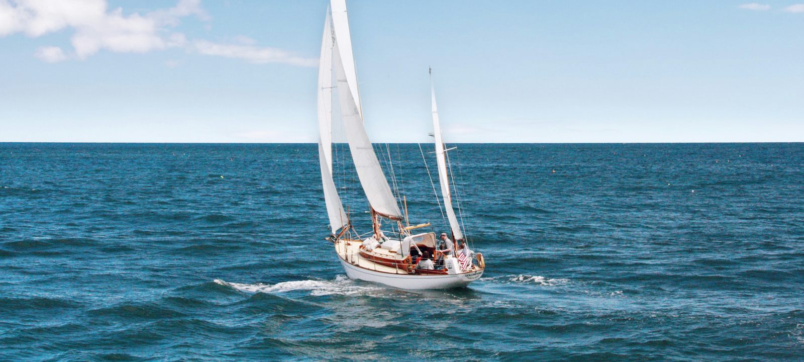 Velero navegando a vela con el mar en calma